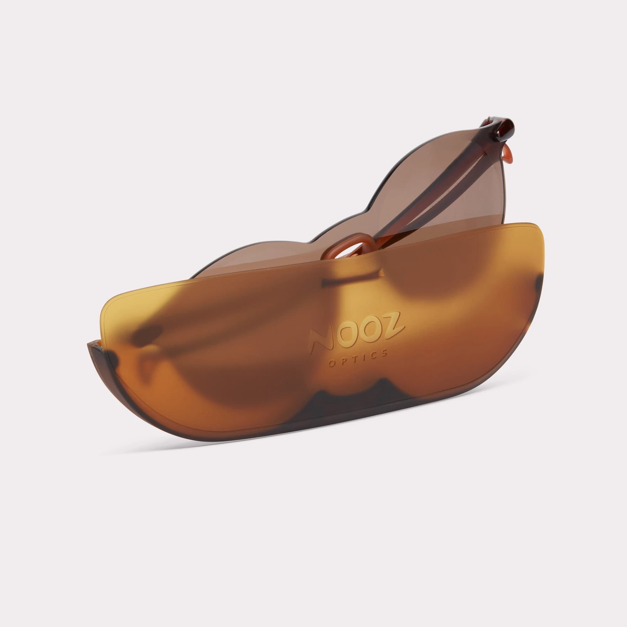 Um par de Essential Sport Round Castanho Óculos escuros saindo do seu estojo